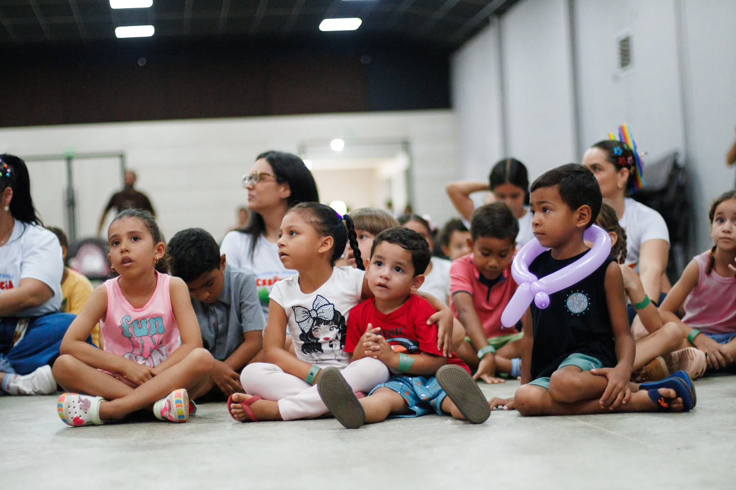 Crianças acompanhando a apresentação com os balões da tarde