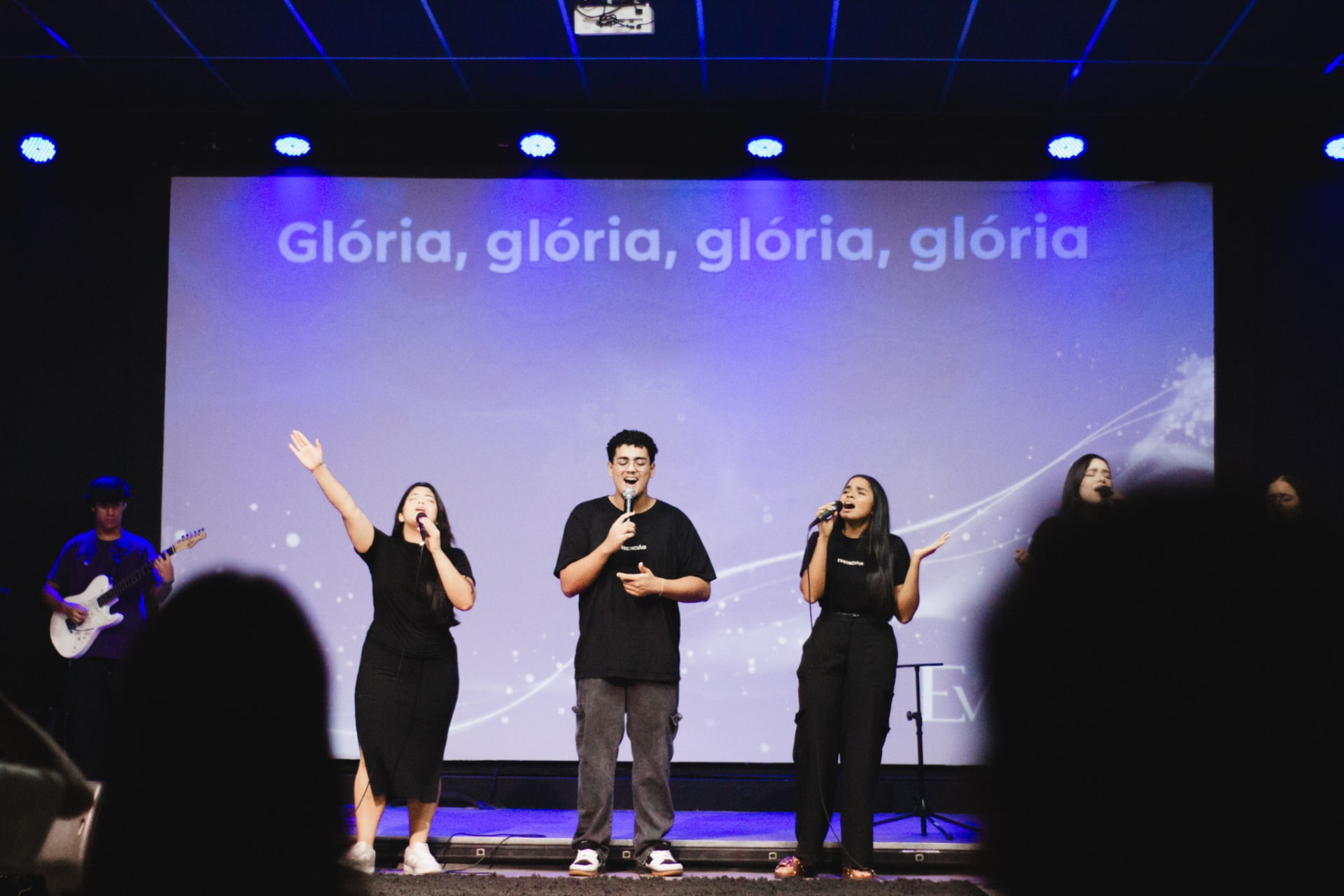 Jovens Essenciais durante momento de louvor no palco
